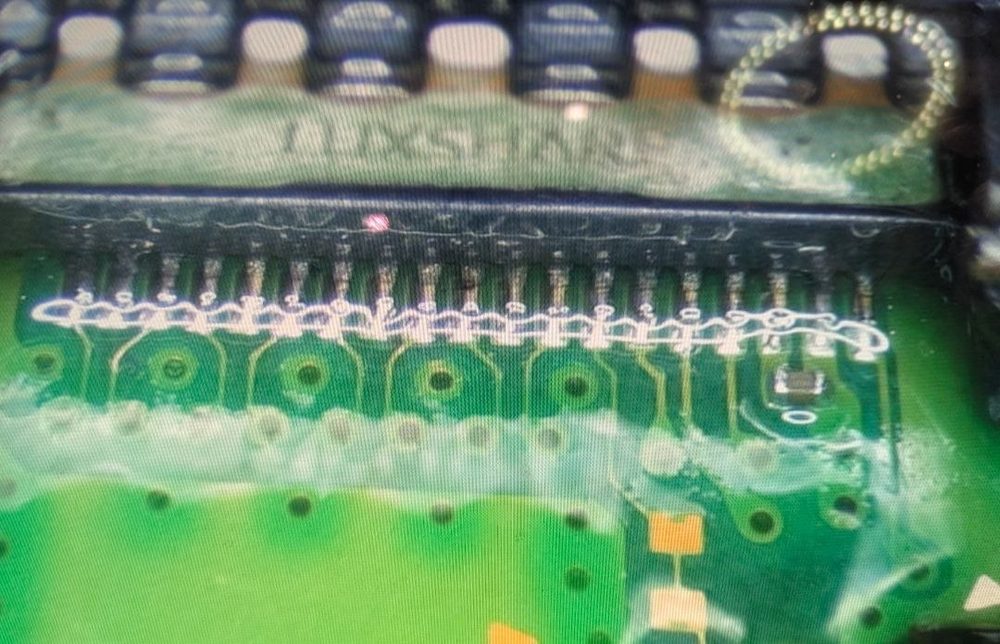 Recently repaired PS5 HDMI port at iFix Erina — shiny solder joints on every pin under magnification, isopropyl applied for inspection